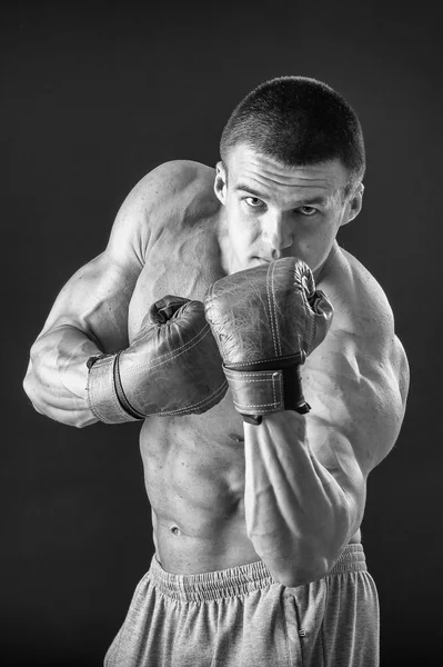 L'uomo con i guanti da boxe. Giovane pugile Boxer su sfondo nero. Boxe pronto a combattere. Boxe, allenamento, muscoli, forza, potenza: il concetto di allenamento della forza e pugilato — Foto Stock