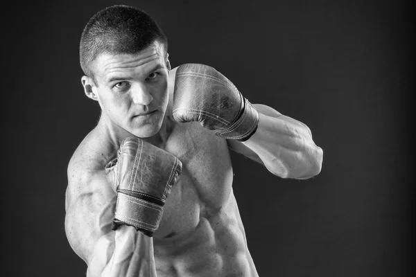 L'uomo con i guanti da boxe. Giovane pugile Boxer su sfondo nero. Boxe pronto a combattere. Boxe, allenamento, muscoli, forza, potenza: il concetto di allenamento della forza e pugilato — Foto Stock