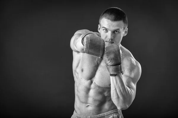 L'uomo con i guanti da boxe. Giovane pugile Boxer su sfondo nero. Boxe pronto a combattere. Boxe, allenamento, muscoli, forza, potenza: il concetto di allenamento della forza e pugilato — Foto Stock