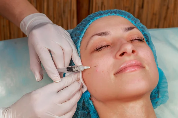 Cosmetic injection in the spa salon. Beautician makes injection into the patient's face. Beauty injections, mesotherapy, revitalization, cosmetic medicine injection - the concept of rejuvenation. — Stock Photo, Image