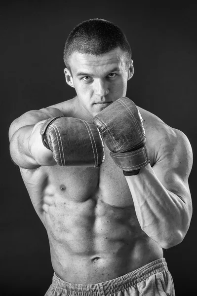 L'uomo con i guanti da boxe. Giovane pugile Boxer su sfondo nero. Boxe pronto a combattere. Boxe, allenamento, muscoli, forza, potenza: il concetto di allenamento della forza e pugilato — Foto Stock