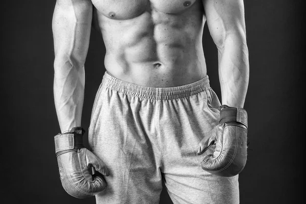 O homem de luvas de boxe. Jovem lutador Boxer sobre fundo preto. Homem de boxe pronto para lutar. Boxe, treino, músculo, força, poder - o conceito de treinamento de força e boxe — Fotografia de Stock