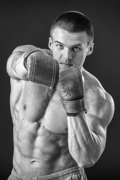 De man in bokshandschoenen. Jonge bokser vechter op zwarte achtergrond. Boksen man klaar om te vechten. Boksen, training, spiermassa, kracht, macht - het concept van krachttraining en boksen — Stockfoto