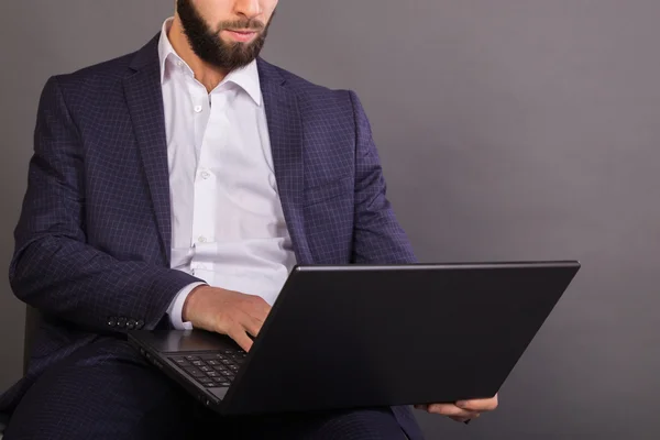 Junger, erfolgreicher Mann im Business-Anzug mit Laptop in der Hand — Stockfoto