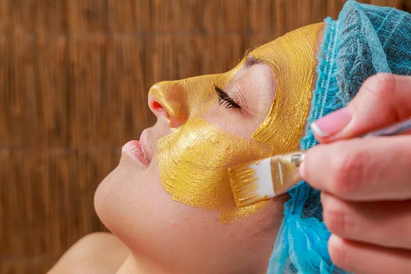 Stosowania złotej maski na twarzy modelu. Zabiegów kosmetycznych — Zdjęcie stockowe