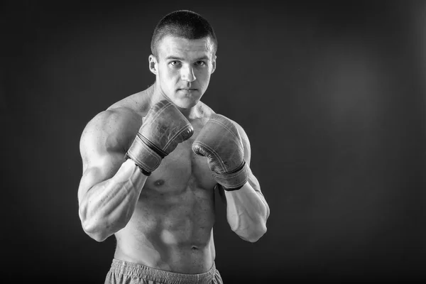 O homem de luvas de boxe. Jovem lutador Boxer sobre fundo preto. Homem de boxe pronto para lutar. Boxe, treino, músculo, força, poder - o conceito de treinamento de força e boxe — Fotografia de Stock