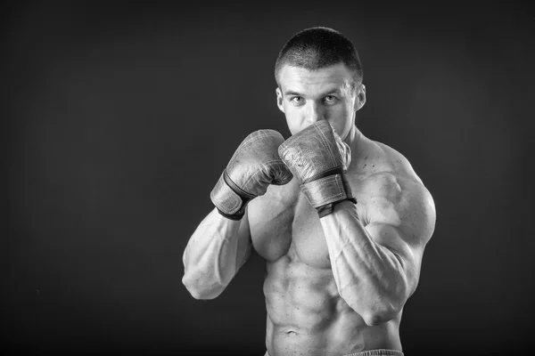 L'uomo con i guanti da boxe. Giovane pugile Boxer su sfondo nero. Boxe pronto a combattere. Boxe, allenamento, muscoli, forza, potenza: il concetto di allenamento della forza e pugilato — Foto Stock