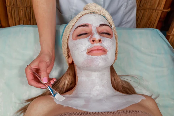 Chica con una esteticista en el salón de spa. esteticista realiza procedimientos cosméticos. Aplicación de crema cosmética. Cosmetología, facial, belleza - El concepto de cuidado de la piel facial. Artículo sobre cosmetología . —  Fotos de Stock