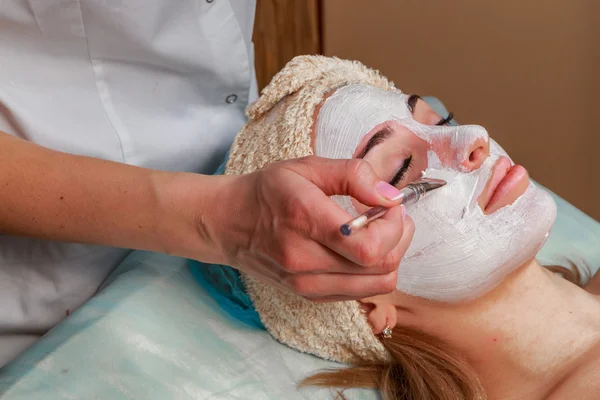 Ragazza con un estetista al centro benessere. Estetista esegue procedure cosmetiche.applicazione di crema cosmetica. Cosmetologia, viso, bellezza - Il concetto di cura della pelle del viso. Articolo sulla cosmetologia . — Foto Stock