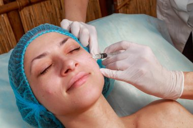 Kozmetik enjeksiyon spa salonda. Güzellik uzmanı hastanın yüz içine enjeksiyon yapar. Güzellik enjeksiyonları, Mezoterapi, yeniden canlandırılması, kozmetik tıp enjeksiyon - gençleştirme kavramı.