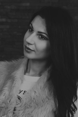 Karanlık bir arka plan üzerinde güzel, gizemli, şirin esmer. Siyah ve beyaz fotoğraf güzel gizemli esmer.