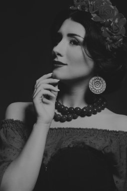 Karanlık bir arka plan üzerinde güzel, gizemli, şirin esmer. Siyah ve beyaz fotoğraf güzel gizemli esmer.