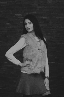 Karanlık bir arka plan üzerinde güzel, gizemli, şirin esmer. Siyah ve beyaz fotoğraf güzel gizemli esmer.