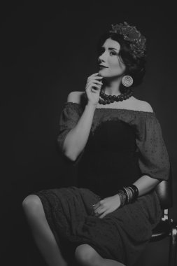 Karanlık bir arka plan üzerinde güzel, gizemli, şirin esmer. Siyah ve beyaz fotoğraf güzel gizemli esmer.