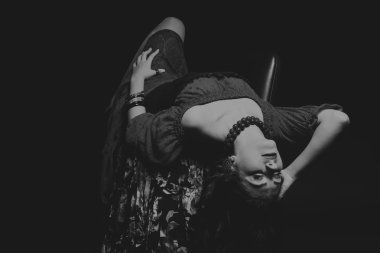 Karanlık bir arka plan üzerinde güzel, gizemli, şirin esmer. Siyah ve beyaz fotoğraf güzel gizemli esmer.