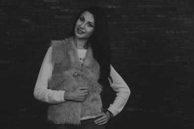 Karanlık bir arka plan üzerinde güzel, gizemli, şirin esmer. Siyah ve beyaz fotoğraf güzel gizemli esmer.