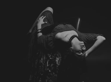 Karanlık bir arka plan üzerinde güzel, gizemli, şirin esmer. Siyah ve beyaz fotoğraf güzel gizemli esmer.