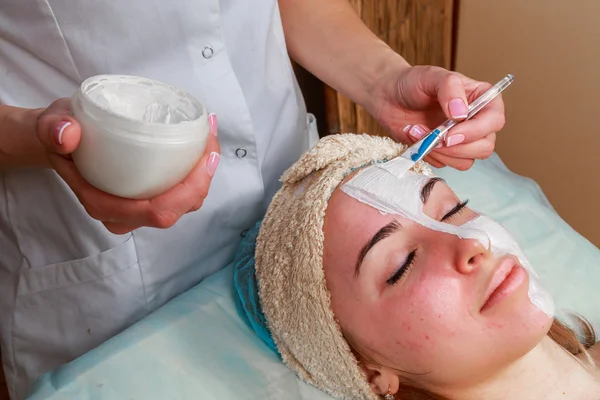 Chica con una esteticista en el salón de spa. esteticista realiza procedimientos cosméticos. Aplicación de crema cosmética. Cosmetología, facial, belleza - El concepto de cuidado de la piel facial. Artículo sobre cosmetología . —  Fotos de Stock