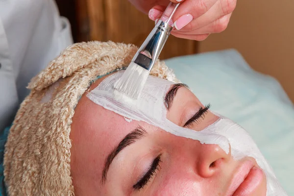 Chica con una esteticista en el salón de spa. esteticista realiza procedimientos cosméticos. Aplicación de crema cosmética. Cosmetología, facial, belleza - El concepto de cuidado de la piel facial. Artículo sobre cosmetología . —  Fotos de Stock