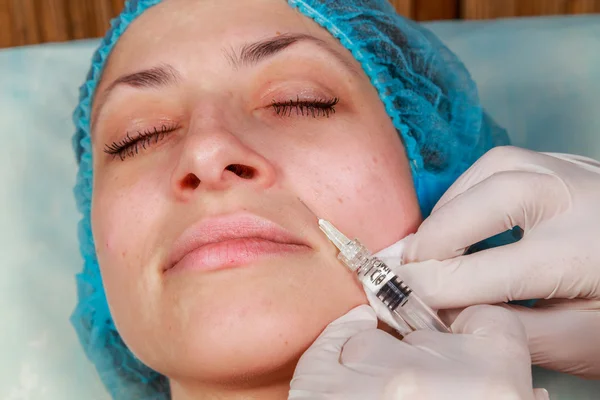 Cosmetic injection in the spa salon. Beautician makes injection into the patient's face. Beauty injections, mesotherapy, revitalization, cosmetic medicine injection - the concept of rejuvenation. — Stock Photo, Image