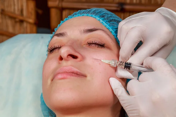 Injection cosmétique dans le spa. L'esthéticienne fait une injection dans le visage du patient. Injections de beauté, mésothérapie, revitalisation, injection de médicaments cosmétiques - le concept de rajeunissement . — Photo