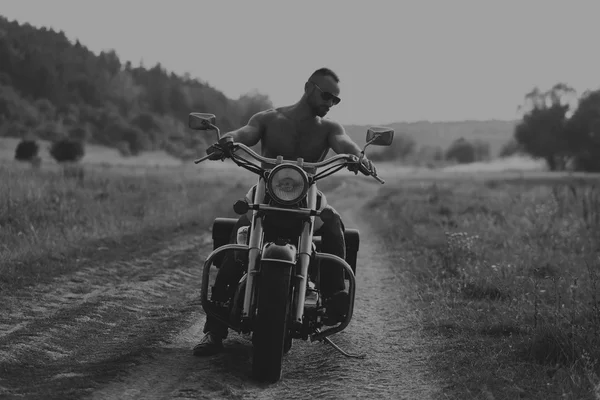 Cool muskulös kille på en motorcykel — Stockfoto