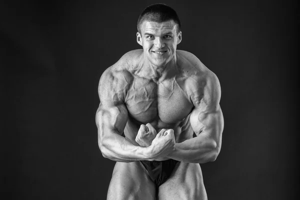 Bodybuilder posieren in verschiedenen Posen und demonstrieren ihre Muskeln. Scheitern auf dunklem Hintergrund. Männchen mit angespannten Muskeln. schöner muskulöser Körper Athlet. — Stockfoto