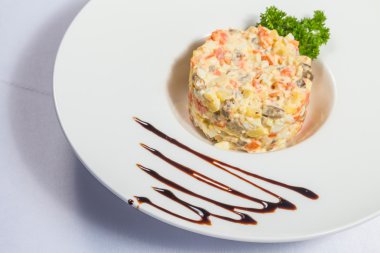 Beyaz tabakta Rus salatası.