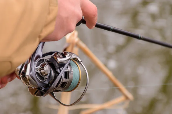 Fishing in river.A fisherman with a fishing rod on the river bank. Man fisherman catches a fish.Fishing, spinning reel, fish, Breg rivers. - The concept of a rural getaway. Article about fishing. — Stock Photo, Image