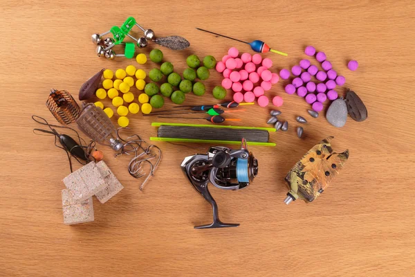 Señuelo de pesca en una mesa de madera. Aparejos de pesca, cebos, flotadores, alimentadores . — Foto de Stock