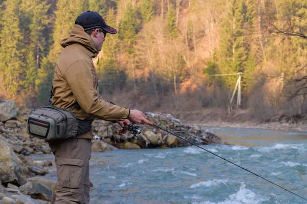 Pescatore sulla riva di un fiume di montagna — Foto Stock