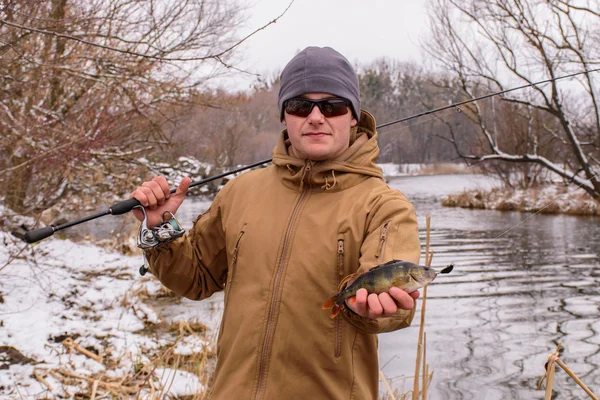 Fishing for perch. Fisherman on the river bank. Sport fishing. The caught fish. — Stock Photo, Image