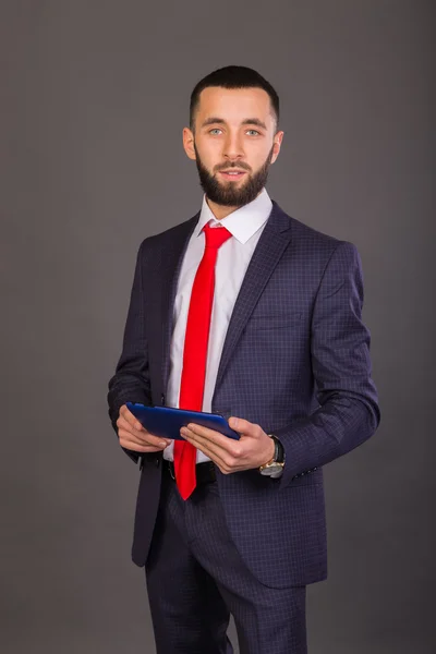 The man in the suit with the phone, tablet