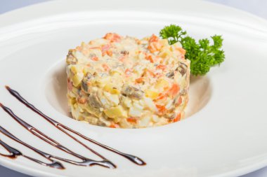 Beyaz tabakta Rus salatası.