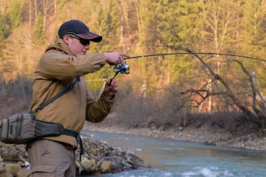 Balıkçı bir dağ nehir kıyısında