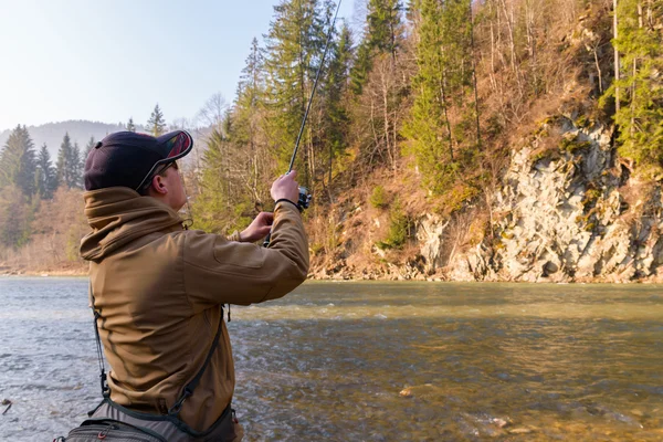 Pescatore sulla riva di un fiume di montagna — Foto Stock