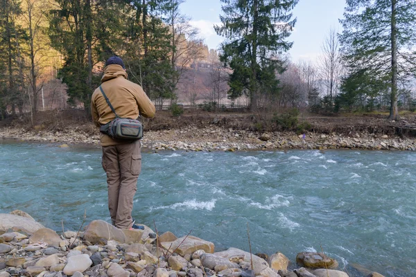 Pescador na margem de um rio de montanha — Fotografia de Stock