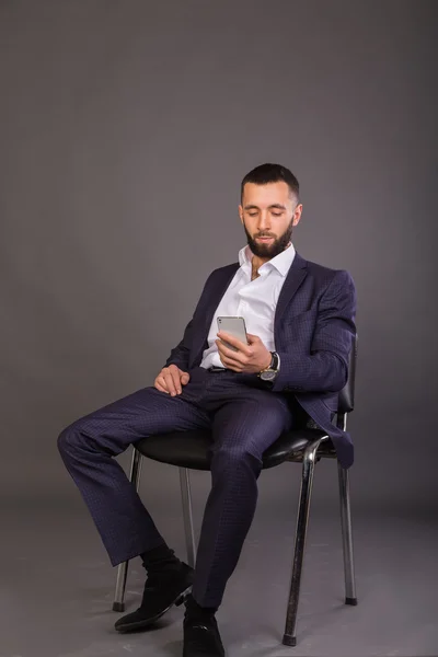Mobiltelefon i händerna på en ung affärsman — Stockfoto