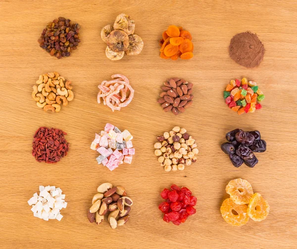 Dried fruits, nuts, candied fruits piled heaps on wooden table