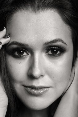 Karanlık bir arka plan üzerinde güzel, gizemli, şirin esmer. Siyah ve beyaz fotoğraf güzel gizemli esmer.