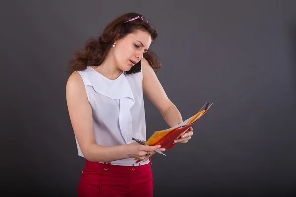 Chica de negocios con una carpeta para papeles y teléfono —  Fotos de Stock