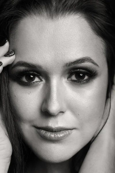 Karanlık bir arka plan üzerinde güzel, gizemli, şirin esmer. Siyah ve beyaz fotoğraf güzel gizemli esmer.