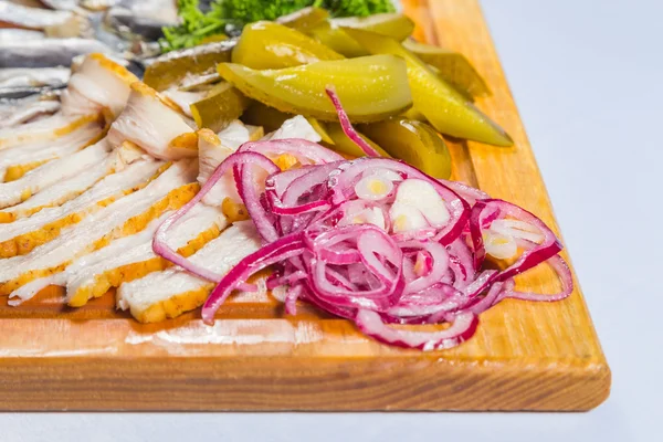 Snack for vodka. Wooden board with snacks. Bacon, pickles, herring and sprat. — Stock Photo, Image