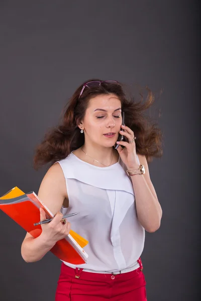 Menina de negócios com uma pasta para papéis e telefone — Fotografia de Stock