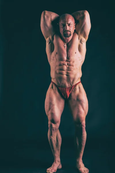 Großer Bodybuilder auf dunklem Hintergrund — Stockfoto