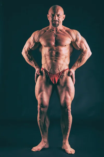 Großer Bodybuilder auf dunklem Hintergrund — Stockfoto