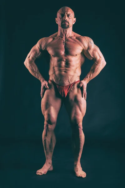 Grand bodybuilder sur un fond sombre — Photo