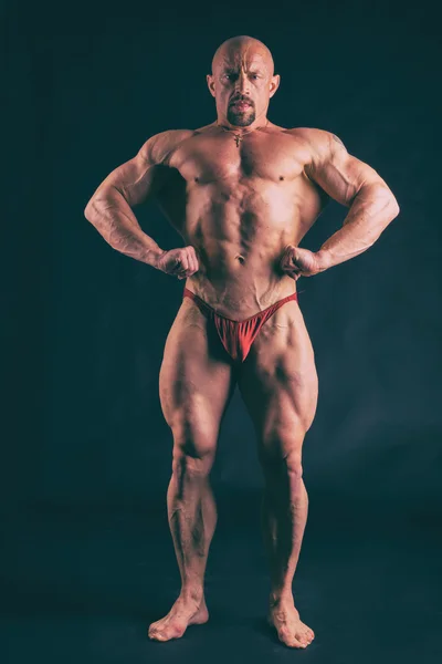 Big bodybuilder on a dark background — Stock Photo, Image