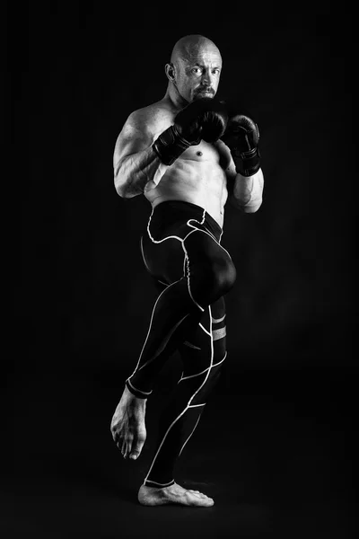 Bodybuilder avec gants de boxe sur fond noir — Photo