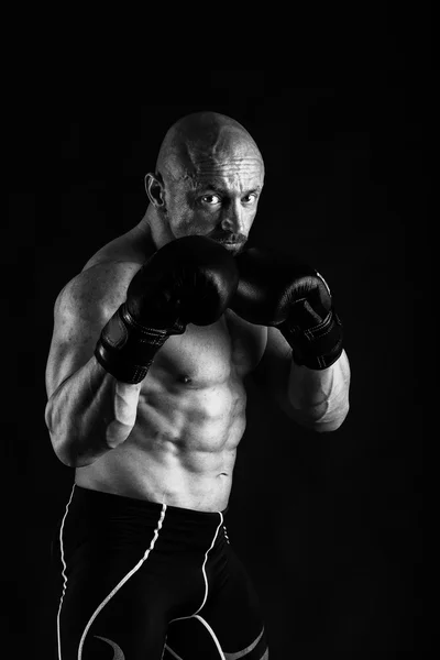 Bodybuilder mit Boxhandschuhen auf schwarzem Hintergrund — Stockfoto